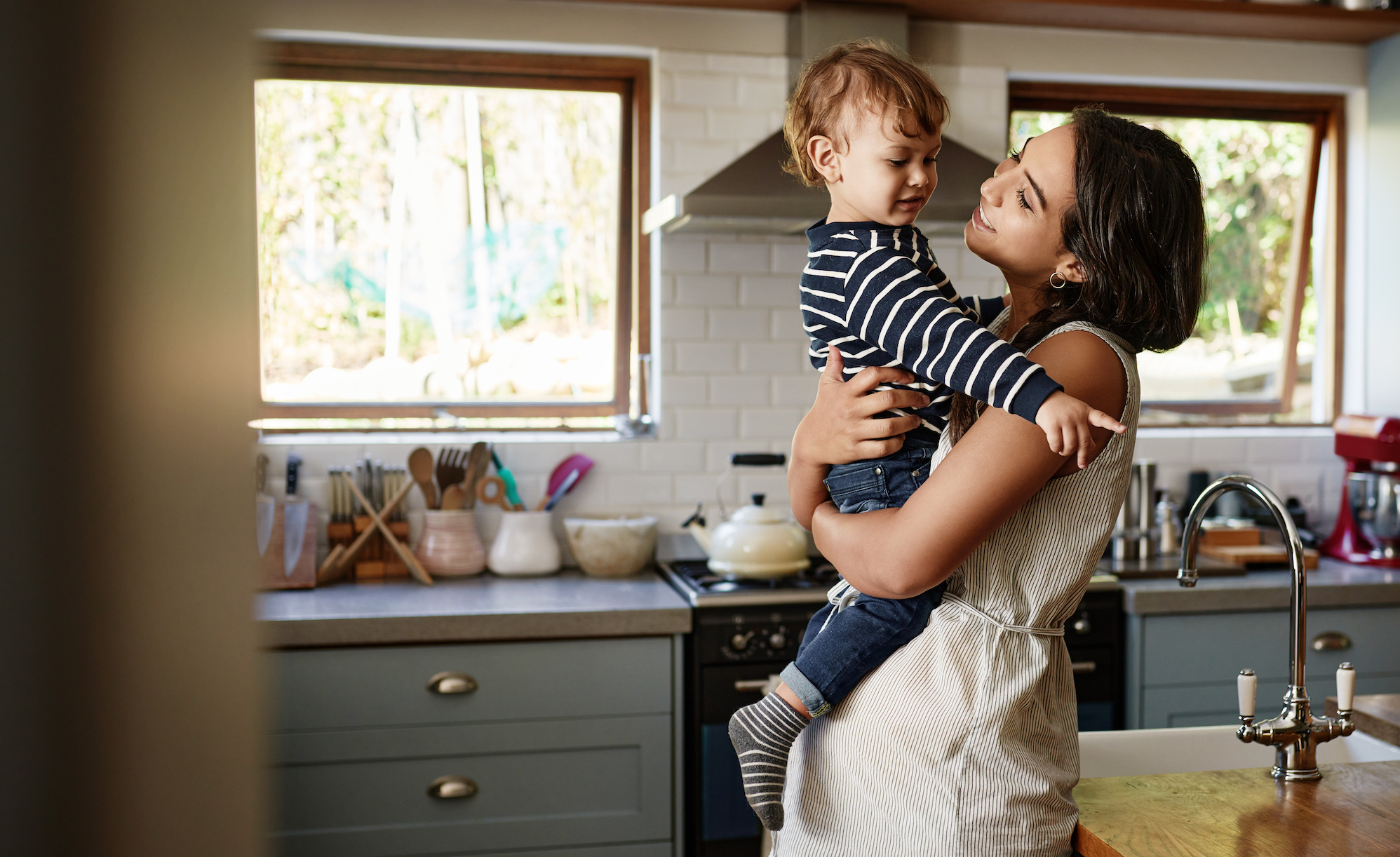 Mom holding son in kitchen